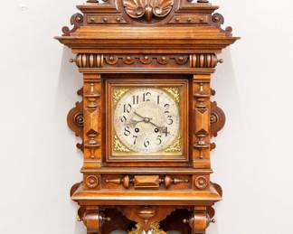 Lot 152: A turn of the century Lenzkirch No. 80 Freischwinger wall clock.  Series 26, 8-day spring driven time and strike movement with engraved Silvered dial, Arabic numerals and fancy cast Brass pendulum, serial #1 Million 229965 indicates a production date of 1900.  Walnut case with carved shell crest over a square dial door with turned pilasters and lower shaped bracket drop.  Old finish with some wear, replaced center finial, running when cataloged.  37 1/2" high overall.  ESTIMATE $600-800
