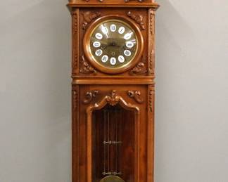 Lot 160:  A 20th century Gazo second model "Santa Barbara" wall clock.  8-day spring driven time and strike movement with quarter hour Westminster/St. Michael/Whittington chimes, engraved Brass dial with porcelain markers and Roman Numerals, engraved Brass pendulum bob.  Second Baroque Style hand carved Walnut case with scrolled foliate crest over a single door with convex dial glass and shaped beveled lower, flanked by foliate pilasters above a shaped molded drop with carved finial.  Case marked "SB-709-W" which indicates "Santa Barbara, Serial #709, Walnut".   Minor wear, slight fading, running when cataloged.  57" high overall.  ESTIMATE $600-800
