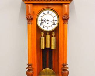 Lot 169:  A late 19th century Gustav Becker wall clock.  8-day weight driven time and strike movement with quarter hour Grand Sonnerie chime and two part porcelain dial with Roman numerals and molded Brass bezel, serial #388584.  Altdeutsch style Walnut case with carved crest over a single long door with arched glass flanked by fluted pilasters with carved detail over a shaped drop.  Older finish with some wear and minor damage, some replaced finials, dial hairlines, running when cataloged.  50 1/2" high overall.  ESTIMATE $600-800
