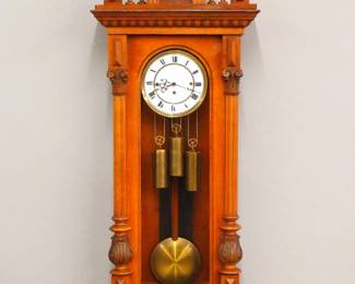 Lot 172:  A late 19th century Vienna Regulator wall clock.  8-day weight driven time and strike movement with quarter hour Grand Sonnerie chime and two part porcelain dial with Roman numerals and molded Brass bezel, serial #388584.  Altdeutsch style Walnut case with carved crest over a single long door with arched glass flanked by fluted pilasters with carved detail over a shaped drop.  Older finish with some wear and minor damage, replaced finials, dial hairlines, running when cataloged.  50 1/2" high overall.  ESTIMATE $600-800

