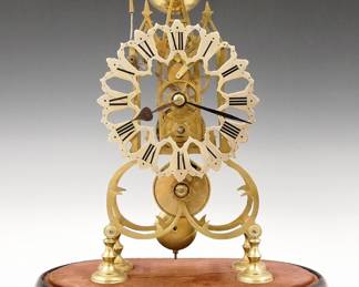 Lot 195: A 20th century Brass Skeleton clock.&nbsp; 8-day Fusee driven movement with passing strike and Silvered cut out dial with Roman numerals.  Shaped Brass plates with turned posts on a molded wooden base.&nbsp; Minor wear, lacks glass dome, running when cataloged.&nbsp; 14 3/4" high overall.&nbsp; ESTIMATE $400-600
