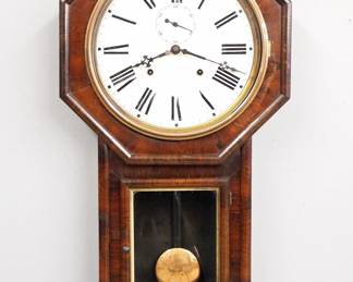 Lot 206: A late 19th century E. N. Welch "Verdi" model Schoolhouse clock.  8-day time and strike movement with painted metal dial and Roman numerals, subsidiary seconds.  Rosewood long drop case with octagon top and molded lower door with Gilded liner.  Paper label verso 50% intact.  Old finish, some wear, minor dial wear, running when cataloged.  31 1/4" high overall.  ESTIMATE $300-400
