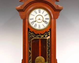 Lot 217:  A late 19th century New Haven "Lena" model shelf clock.  8-day time and strike movement with papered metal dial and Roman numerals.  Walnut case with carved pediment crest and finial over a single arched door with reverse painted glass and molded base.  Paper label 70% intact.  Older refinishing with minor wear, replaced dial, base and finial.  27 3/4" high overall.  ESTIMATE $300-400
