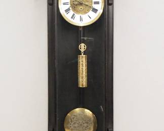 Lot 220: A late 19th century Vienna regulator wall clock.  8-day weight driven time only movement with two part Brass/porcelain dial with Roman numerals and molded Brass bezel, etched dial center, weight and pendulum.  Ebonized case with arched crown over a single long door with arched glass flanked by  pilasters with shaped detail over a shaped drop.  Old finish with some wear, dial hairlines, running when cataloged.  36 3/4" high overall.  ESTIMATE $300-400
