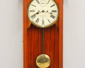 Lot 218:  A turn of the century New Haven "Vamoose" model wall regulator.  30-day dual wind time only movement with a painted metal dial, Roman numerals and subsidiary seconds.  Softwood case with original grain paint features a shaped crest over a long molded door with arched glass over a bracket drop with turned finial.  Minor wear, restored dial, running when cataloged.  45 1/2" high overall.  ESTIMATE $300-400
