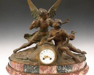Lot 221: A turn of the century French mantel clock.  8-day time and strike movement with convex porcelain dial with Arabic numerals, painted swags and fancy Gilded hands, serial #11206.  Rear plate with "F C" stamped in an oval with a gear.  Patinated Spelter figure of an Angel and Scribe on a Rouge/Verde Marble base with Gilded Bronze detail.  Some wear, point of minute hand missing, rear of case mis-shaped, running when cataloged.  19 1/4" high overall.  ESTIMATE $400-600
