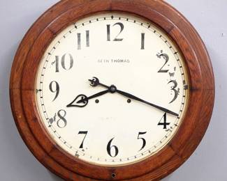 Lot 223:  A late 19th century Seth Thomas "Arcade" model Gallery clock.  30-day dual spring time only movement with 18" painted metal dial and Arabic numerals.  Molded Oak case with lift door.  Some finish wear, dial wear and minor flaking, running when cataloged.  23 1/2" diameter.  ESTIMATE $400-600
