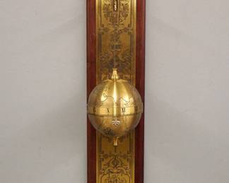 Lot 234: A late 20th century Franklin Mint Falling Ball Gravity clock.  After the original "Sir Francis Drake" clock, made by Thwaites & Reed, England.  8-day time only movement with platform escapement, spherical Brass case with engraved hemispheres, annular time ring with Roman numerals.  Hangs on a shaped Mahogany plaque with engraved Brass panel.  Minor wear, running when cataloged.  30" high overall.  ESTIMATE $200-300
