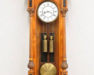 Lot 233:  A late 19th century Junghans wall clock.  8-day weight driven time and strike movement with a two part porcelain dial and Roman numerals and molded Brass bezel.  Altdeutsch Style Walnut case with carved crest over a single long door with arched glass flanked by fluted pilasters with carved detail over a shaped drop.  Older refinishing with some wear and minor damage, restored applied carvings, lacks some small moldings, dial hairlines, running when cataloged.  49" high overall.  ESTIMATE $300-400
