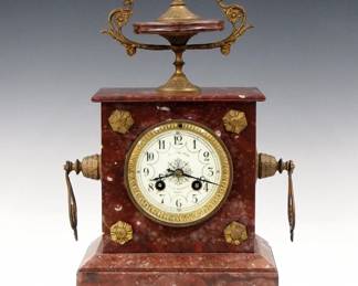 Lot 236: A turn of the century French mantel clock retailed by  "Au Phenix, 16 Rue Lafayette, Paris".  8-day time and strike movement with convex porcelain dial and Arabic numerals.  Rouge Marble case with urn top, Gilded mounts and paw feet.  Some wear and minor repairs to case, running when cataloged.  16 1/2" high overall.  ESTIMATE $200-300
