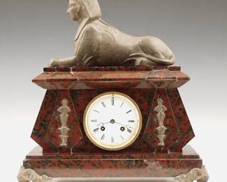 Lot 243: An early 20th century Egyptian Revival Period mantel clock, by Japy Freres, retailed by "Hny Marc, Paris".  8-day time and strike movement with porcelain dial and Roman numerals.  Rouge Marble case with Spelter Sphinx figure, cast mounts and front feet.  Some wear, several glued repairs to marble case, flakes at winding arbors, replaced rear feet, running when cataloged.  14 3/4" high overall.  ESTIMATE $200-300
