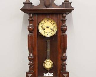 Lot 248: An early 20th century Gustav Becker wall clock.  8-day spring driven time and strike movement with paper dial and Arabic numerals, R/A pendulum.  Walnut case with restored crest and drop.  Refinished with restoration, running when cataloged.  38 1/2" high overall.  ESTIMATE $200-300
