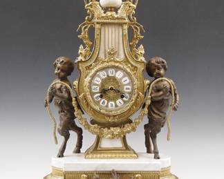 Lot 253: A modern Louis XVI style mantel clock by Franz Hermle & Son, Germany.  8-day time and strike movement with lever escapement, cast Brass dial with Roman numerals on porcelain markers.  Cast Brass case with upper urn finial over an Eagle head crown, central movement housing with foliate swags flanked by young Satyrs on a shaped marble platform and conforming Brass base with paw feet.  Only slight wear, running when cataloged.  24"  high.  ESTIMATE $300-500
