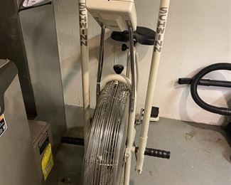 Schwinn Air Dyne bike with attachable rack for book.