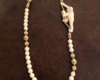 Carved bone/gold-plated necklace with whimsical monkey