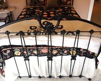 Footboard detail of full sized heavy iron bed.  Bedding is beautiful in this room.  