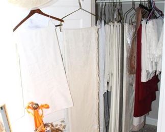 The closet is full of curtains, drapes, and woven spreads.