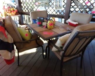 Outside Patio Furniture - Four Chairs and Cushions with a Tile and Metal Table