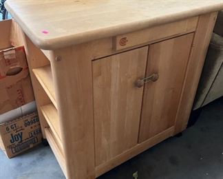 Wheeled kitchen storage cart.  Doors on both sides, plus book case on one end