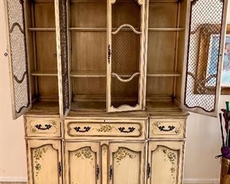 Vintage Stunning  2pc China/Display Hutch by Saginaw Furniture with Wire Mesh on doors and painted in a buttery antique paint (original) with Floral Stencils on Doors and Drawers.  This piece morphs into a secretary, as the center opens out into a desk,  Super impressive Piece from the 1960's