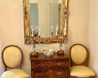 This is a lovely seating area, featuring a Baker lateral file cabinet, and a drawer beneath it, flanked by a pair of oval back side chairs.  A dazzling large mirror, highly decorated and Two French Louis XVI Bronze and  crystal candelabra lamps.  Under the mirror is a footed display bowl antique and hand-painted chrysanthemum bowl.  Ooh la la!