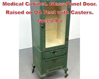Lot 495 Antique Industrial Metal Medical Cabinet. Glass Panel Door. Raised on QA Feet with Casters. Green Pa