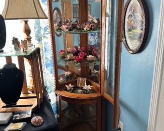 Corner lighted curio, filled with Capodimonte porcelain flowers