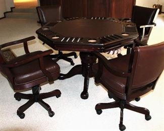 Combination game table with poker table on one side and bumper pool on the other. The table includes four leather, swivel chairs with wheels.