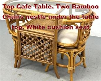 Lot 912 Bamboo Rattan Glass Top Cafe Table. Two Bamboo Chairs nestle under the table top. White cushion seat