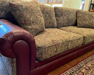 2-cushion, upholstered Mayo sofa with red leather rolled arms and base