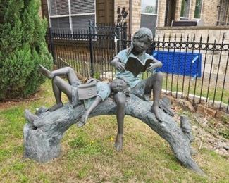 Reading on a Log bronze garden sculpture.
