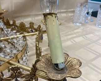 LOT 021- Marked "MADE IN SPAIN" Hollywood regency chandelier in the style of Swarovski AS-IS. There are bent sockets, damage to the metal at the sockets and prism loss. $575 