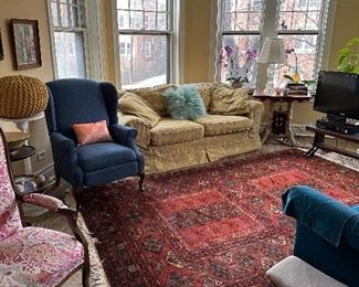 Red afghan rug. Blue recliner, easy chair yellow Quatrine down-filled sofa. Eastlake table.