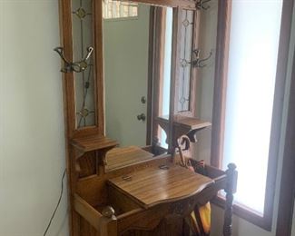 Hall tree which is lighted at the top to highlight the stained glass at the top