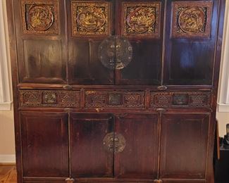 Vintage Asian cabinet with carved detail and metal hardware