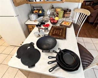 Cast Iron!  Wok is by Jim Beam, skillets I don’t remember. The two pieces to the left are ceramic and they are made by Emily someone and sold william Sonoma… check the later pics for deets.