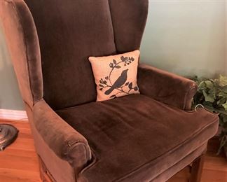 Brown wingback chair; decorative bird pillow