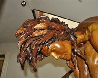 A life size carved wood artwork by Linda Elder.  Title:  PARADOX or A HARD HEADED WOMAN.