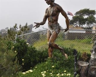 A 10 foot tall wood Chumash woman mounted on a rock created by Linda Elder overlooks the Pacific Ocean.  Title:  OXCHITL