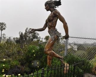 A 10 foot tall wood Chumash woman mounted on a rock created by Linda Elder overlooks the Pacific Ocean.  Title:  OXCHITL