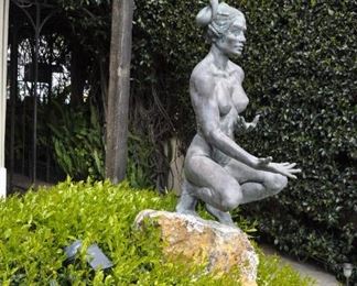 A 3 1/2 foot tall original bronze sculpture (1 of 1) by Linda Elder mounted on a 4 foot tall rock.  Title:  Crouching Woman