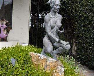 A 3 1/2 foot tall original bronze sculpture (1 of 1) by Linda Elder mounted on a 4 foot tall rock.  Title:  Crouching Woman