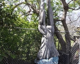 A 10 foot tall carved wood  " Hawk resting on Dolphins " created by David Elder.