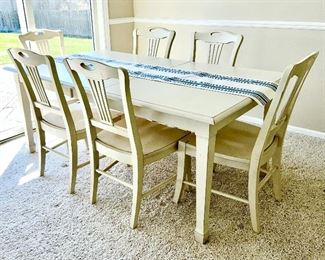 Close-up of French Country distressed style dining table w/ one leaf and 6 chairs