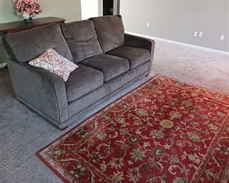 Gray microfiber sofa red floral area rug