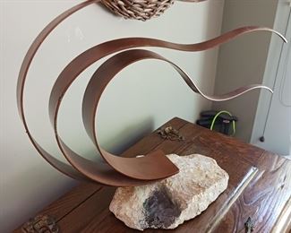 Metal wind flowing sculpture mounted  Rock