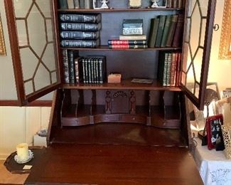 Secretary drops down to  form a writing desk.  Book case  includes  books dated from 1865