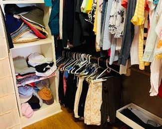 two  closets  filled to the brim with smaller sized lady's  designer  clothing,  shoes,  boots,  and handbags