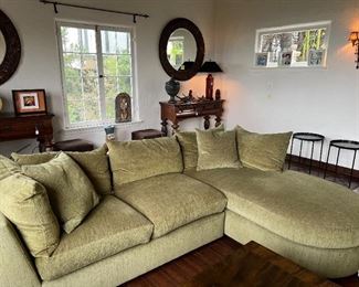 The main subject in this photo is the sofa, but don't ignore the round wall mirrors and tables.