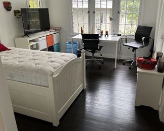 The room with the captain's bed also has a simple desk, television, a couple of office chairs, and a storage system.